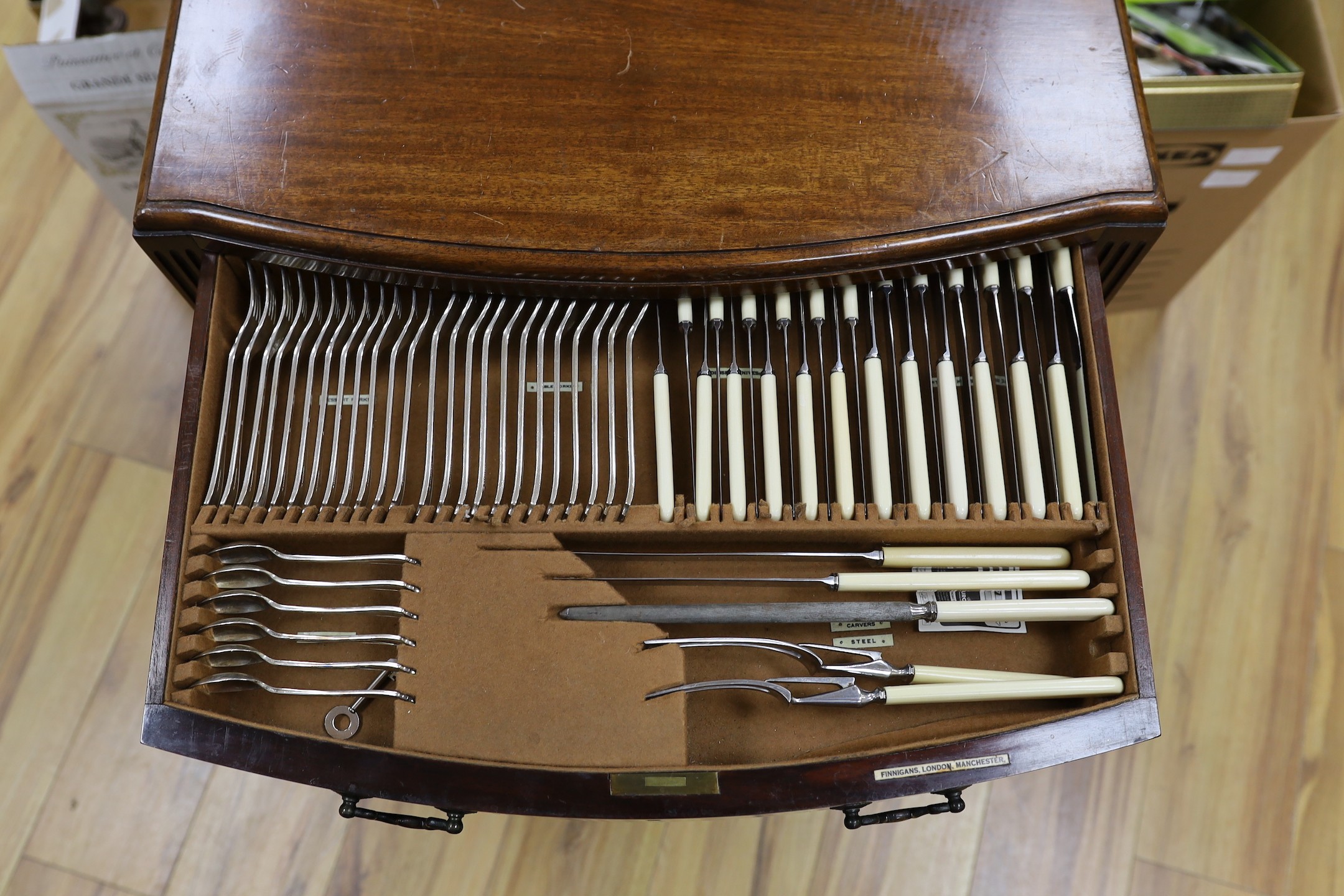 A suite of cutlery, in mahogany two drawer cabinet